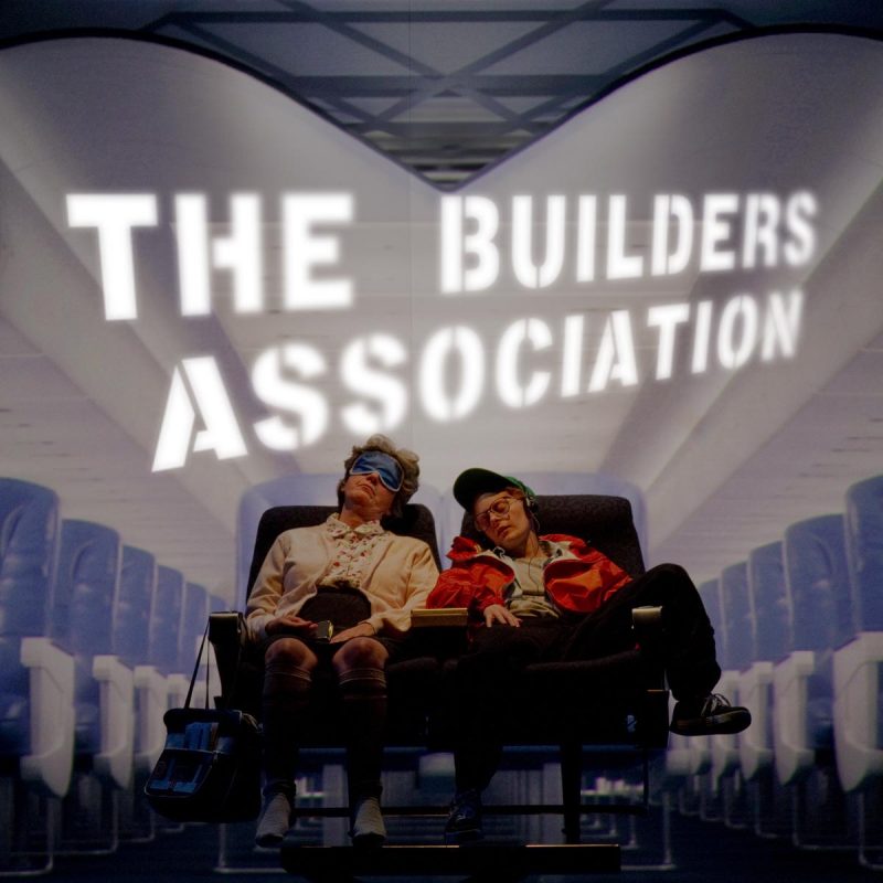 2 people in airplane seats with a projection background of an airplane interior behind them